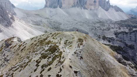 Un-Excursionista-Está-Parado-En-La-Cima-De-Una-Colina-Con-Vistas-A-Tre-Cime-Di-Lavaredo-En-Los-Dolomitas-Del-Norte-De-Italia