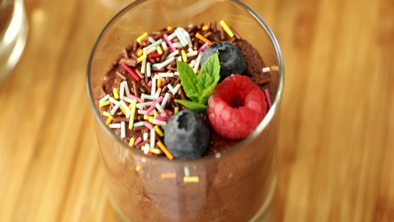 Primo piano di mousse al cioccolato guarnita con frutti di bosco
