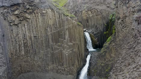 Luftaufnahme-Des-Litlanesfoss-Wasserfalls,-Der-Durch-Die-Klippe-Mit-Basaltsäulen-Im-Osten-Islands-Fließt