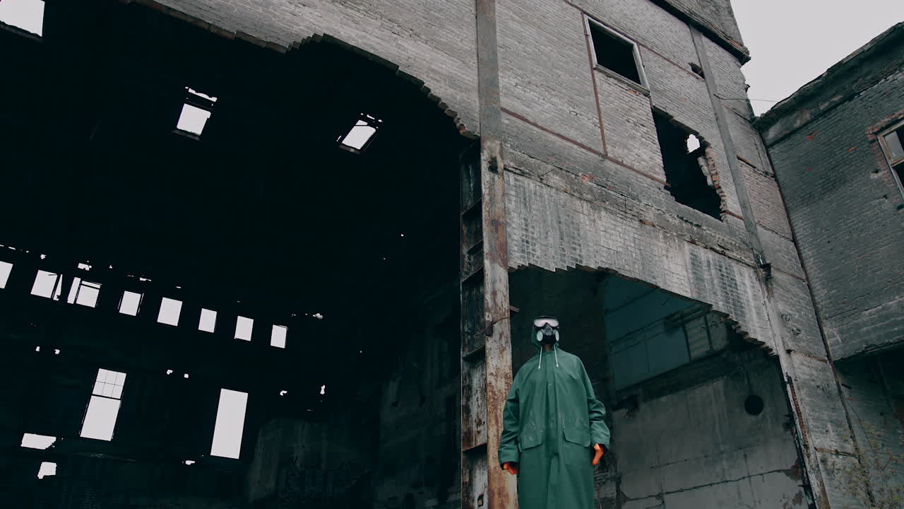 Human in destroyed place. Ruined buildings in infected zone. Person in safety suit and gas mask standing alone in ruined place.