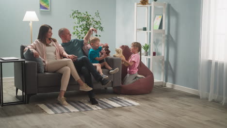 parents rest on sofa while children play with toys at home