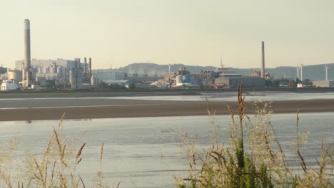 Mirando-A-Través-Del-Estuario-Del-Río-Mersey-Hasta-Las-Empresas-Industriales-De-La-Fábrica-Frente-Al-Mar-Runcorn-Al-Amanecer-Con-La-Marea-Baja.