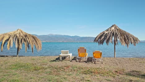 deserted greek beach loungers and palm frond sunshades maliakos bay