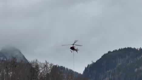 helicopter carrying load over amden, glarus, switzerland