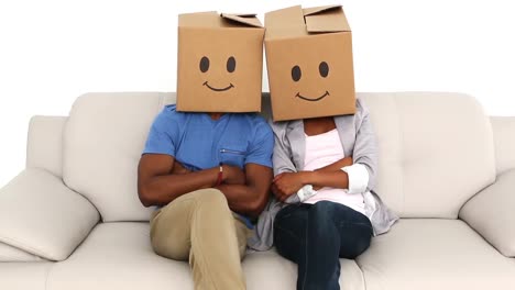 equipo sentado en el sofá con cajas de emoticones en sus cabezas