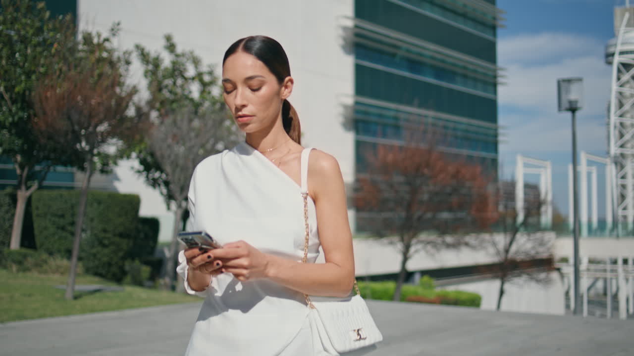 멋진 ceo가 스마트폰으로 업무 문자 메시지를 보내며 니 스트리트를 가까이서 고 있습니다.