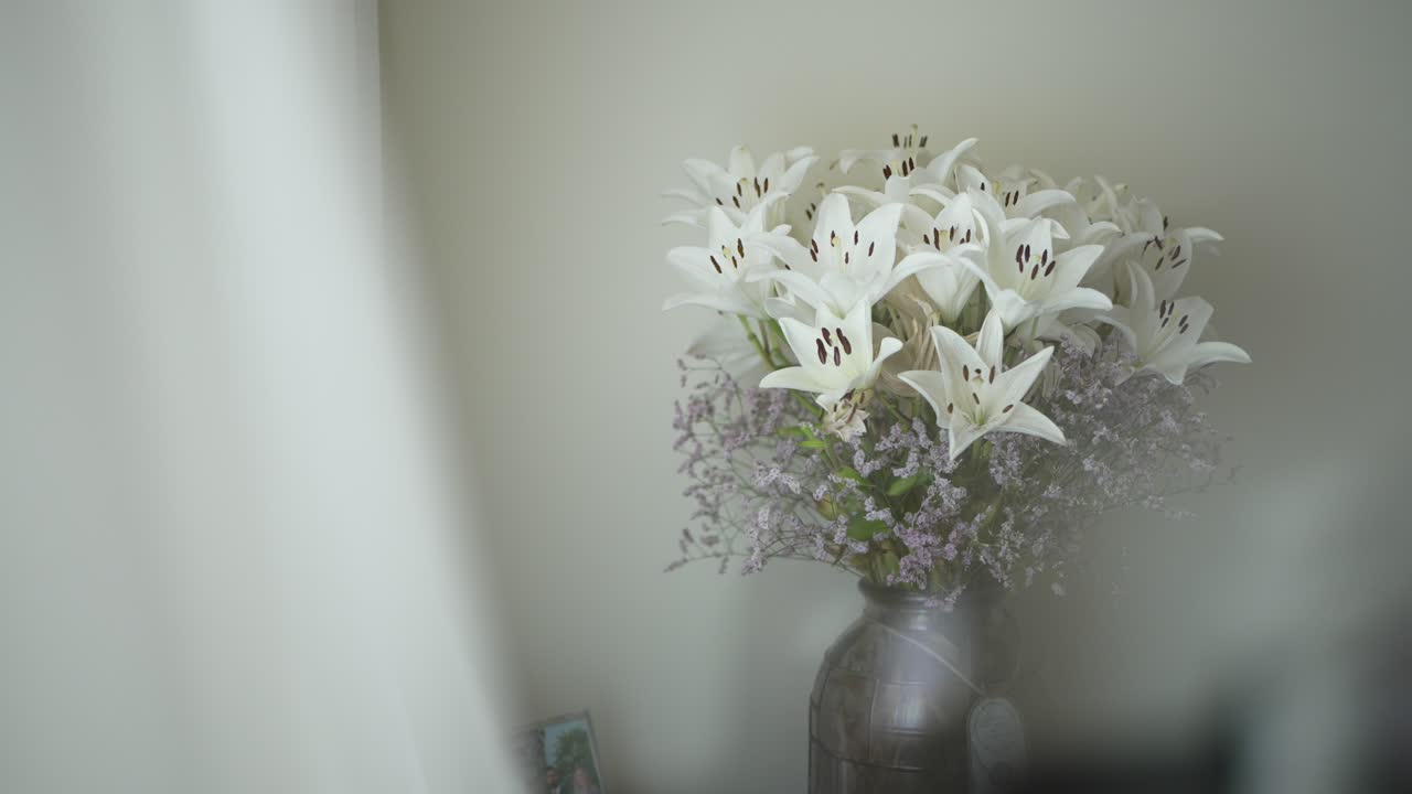 soft focus shot of white lilies in a rustic metal vase, creating a serene and delicate ambiance