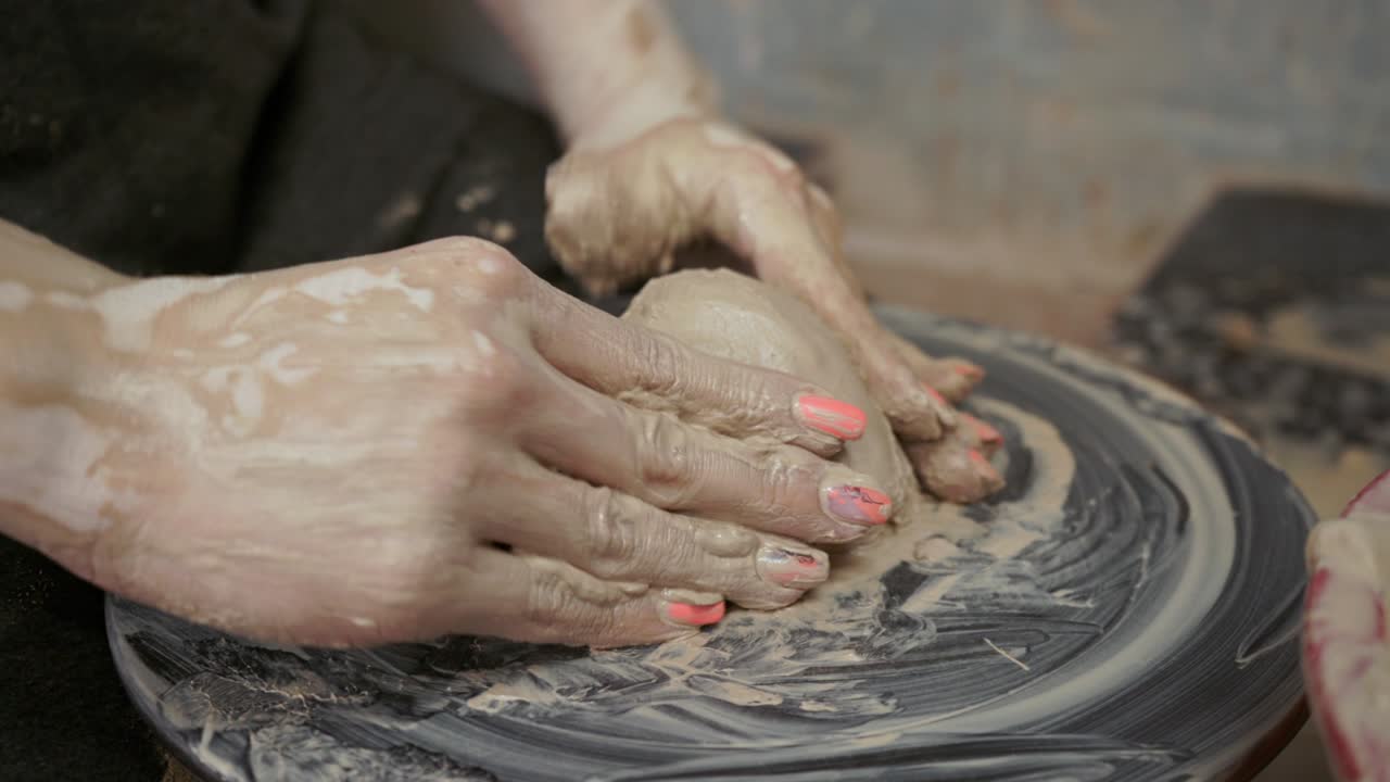 una mujer alfarera hace platos de arcilla. una mujer hace una jarra en la rueda de un alfarero