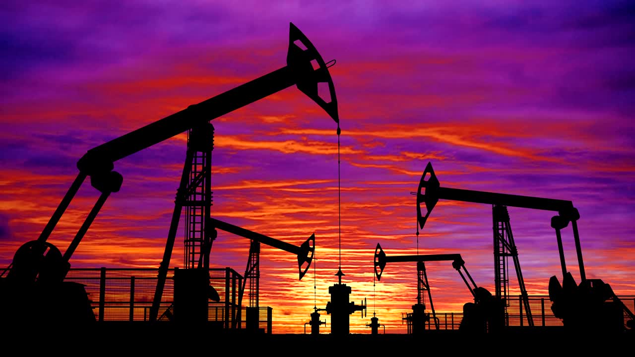 bombas de aceite en bucle contra el cielo rosado del atardecer