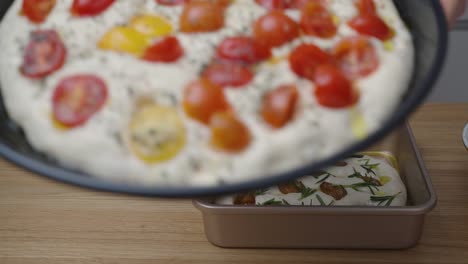 hombre mostrando focaccia de tomate fresco con tapa antes de ponerlo en el horno