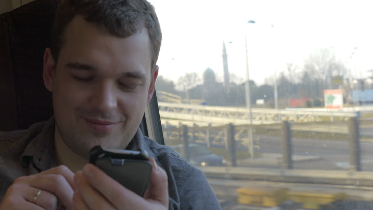 Uomo che chiacchiera al cellulare durante il viaggio in treno
