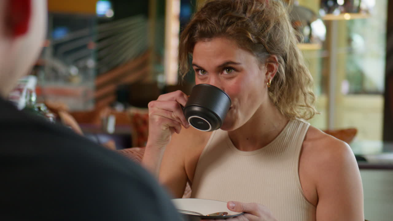 Bella donna in tenuta da jogging che si gode un cappuccino in un lussuoso ambiente alpino nelle Alpi svizzere. Rituale pre-allenamento, concentrazione serena, stile di vita premium e atmosfera montana cinematografica