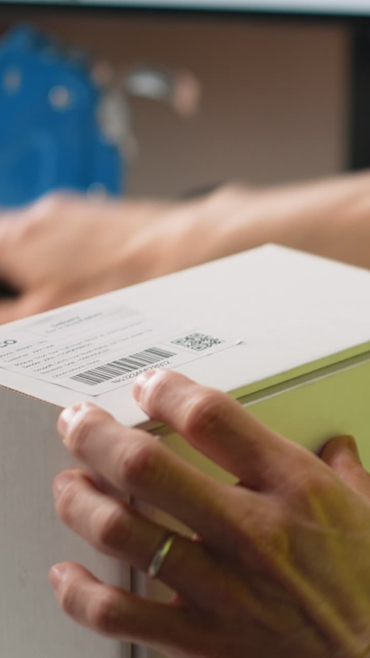 Vertical Video Asian employee applying shipping labels and scanning tracking info