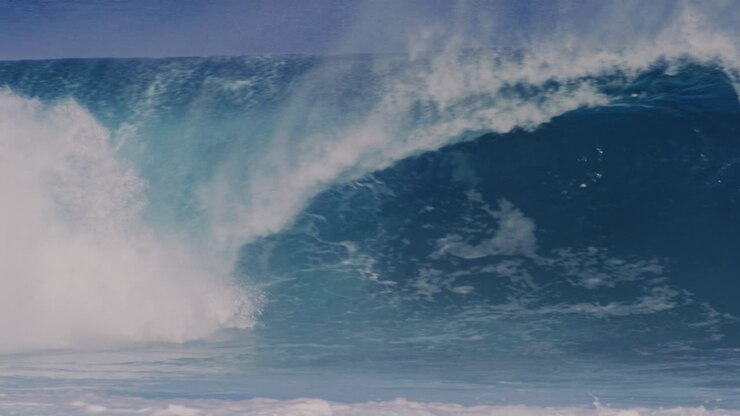 Pan across crashing lip of strong churning water with spray spitting out of barrel, empty water in slow motion