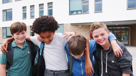 portrait of male high school student friends standing outside school buildings