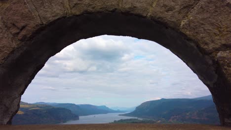 4k nice static view of the columbia river through an archway with mostly cloudy sky take two