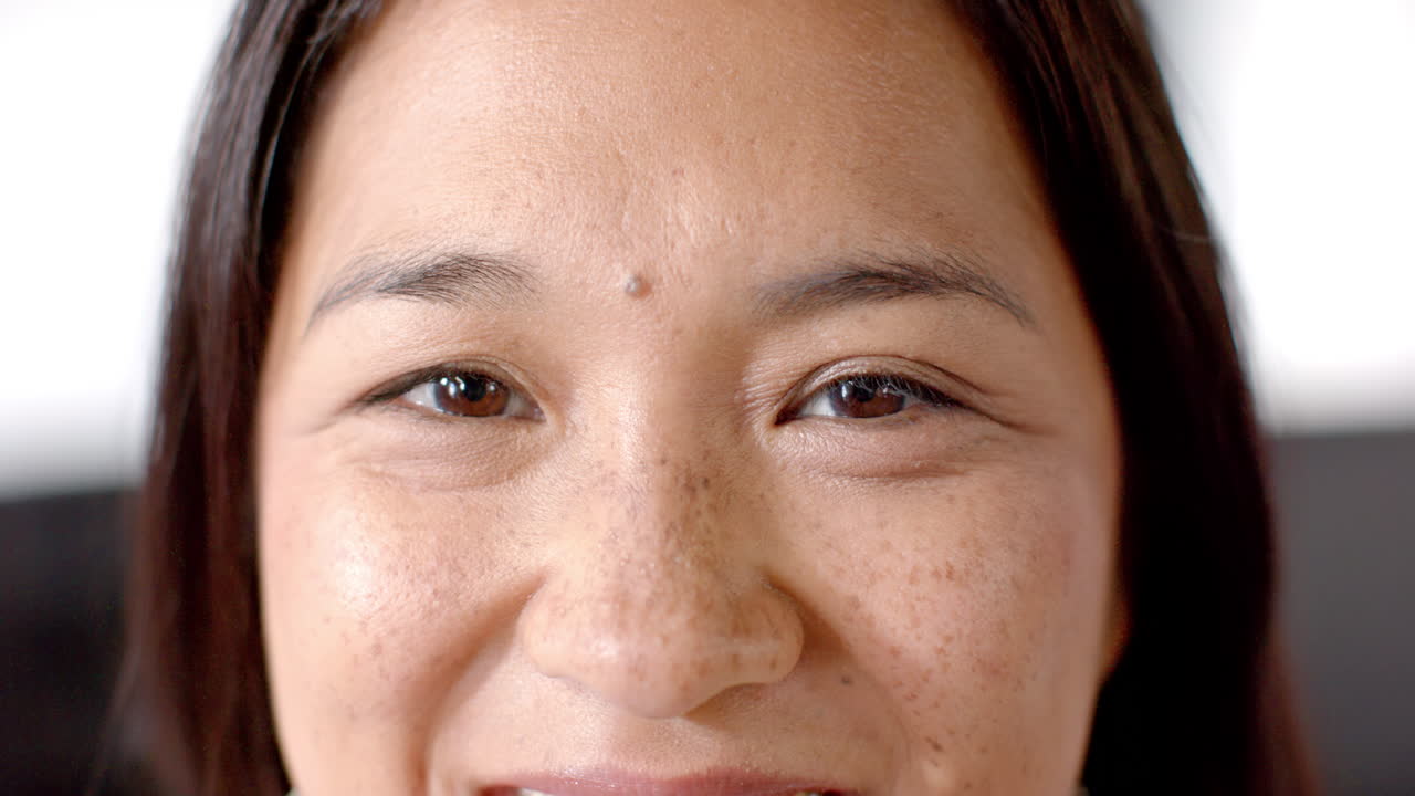 Smiling woman with freckles in close-up portrait, showing natural beauty