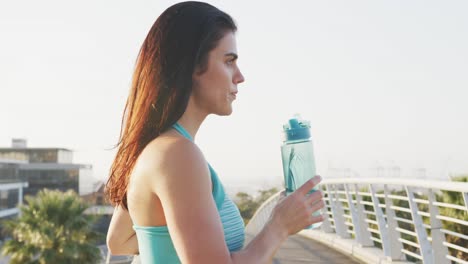 young runner drinking water after running