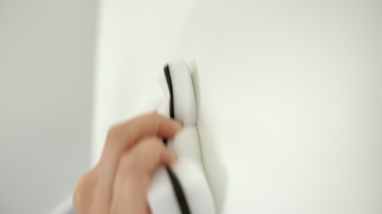 Hand Cleaning And Scrubbing Wall With Sponge. - closeup shot