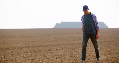 tired and sad farmer walking in farm on sunny day