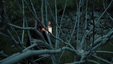 mysterious young woman walk a scary dry tree branches in the night forest