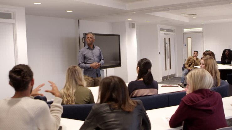 Male teacher talking with students in a university classroom, shot on R3D