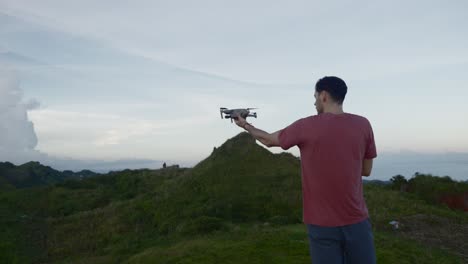 joven viajero masculino volando un avión no tripulado en el paisaje escénico de la naturaleza en las filipinas