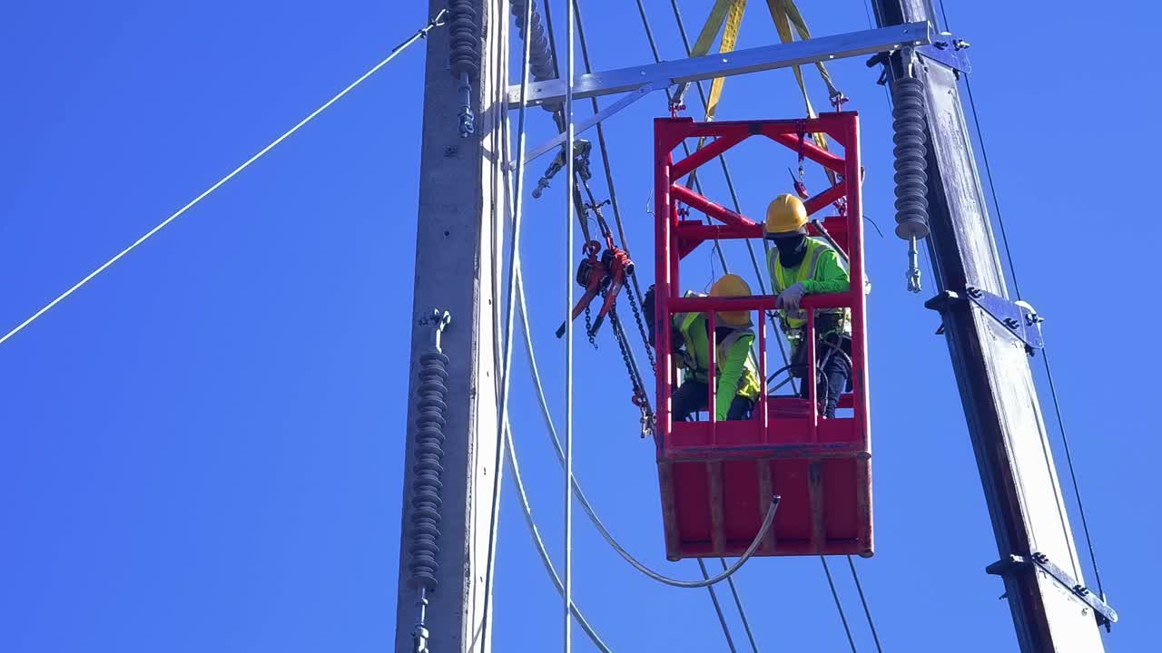 electricistas que trabajan en líneas eléctricas