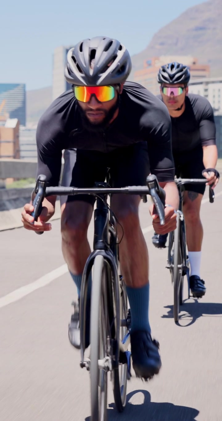 Due ciclisti professionisti in sella a bici da corsa in una giornata di sole