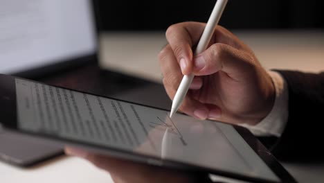 hombre de negocios firmando un contrato de negocio con bolígrafo en la tableta por la noche. hombre firmando contrato en la tablet en la oficina. concepto de negocios y tecnología. concepto de firma electrónica