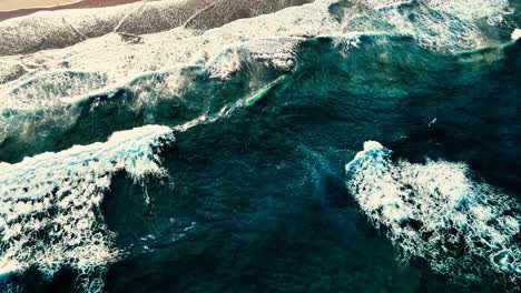 un dron captura las olas que se estrellan en la costa de oro.