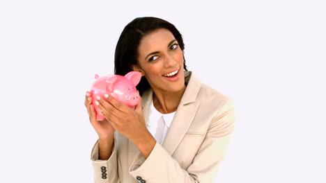 businesswoman shaking piggy bank