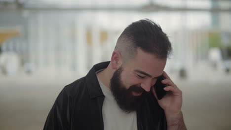 smiling young brunet talking on smartphone outdoor.