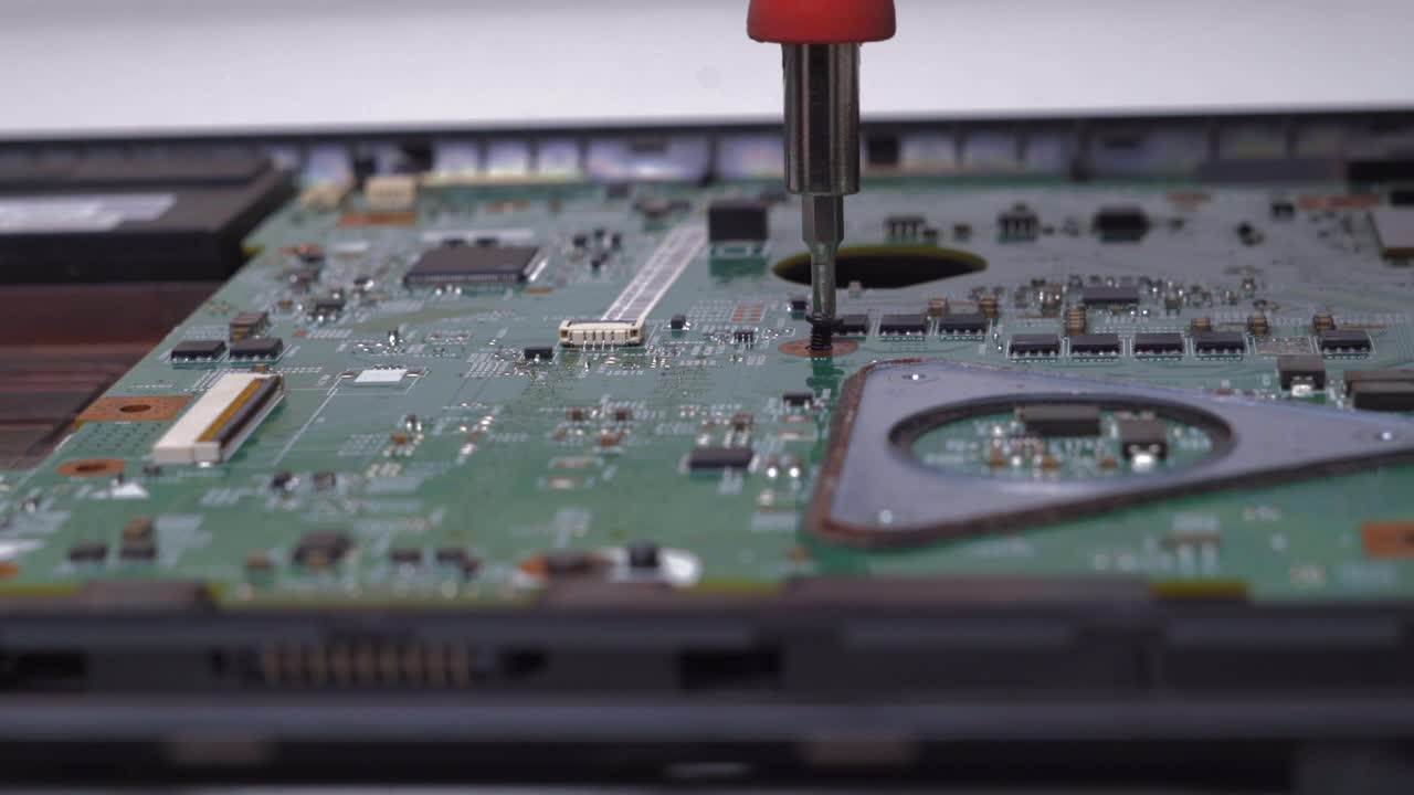 la placa base de componentes del portátil apretando el tornillo ensamblando las piezas a mano
