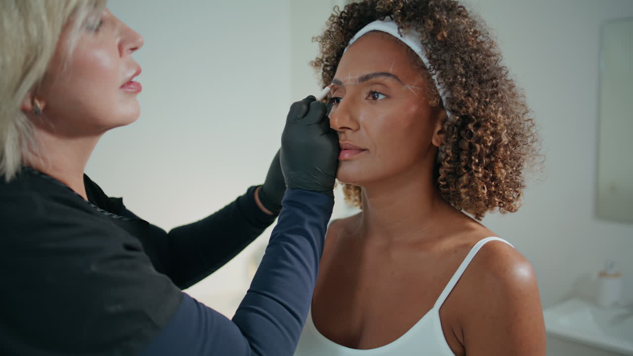 maestro de belleza haciendo corrección de cejas en primer plano. hermosa paciente visitando la clínica