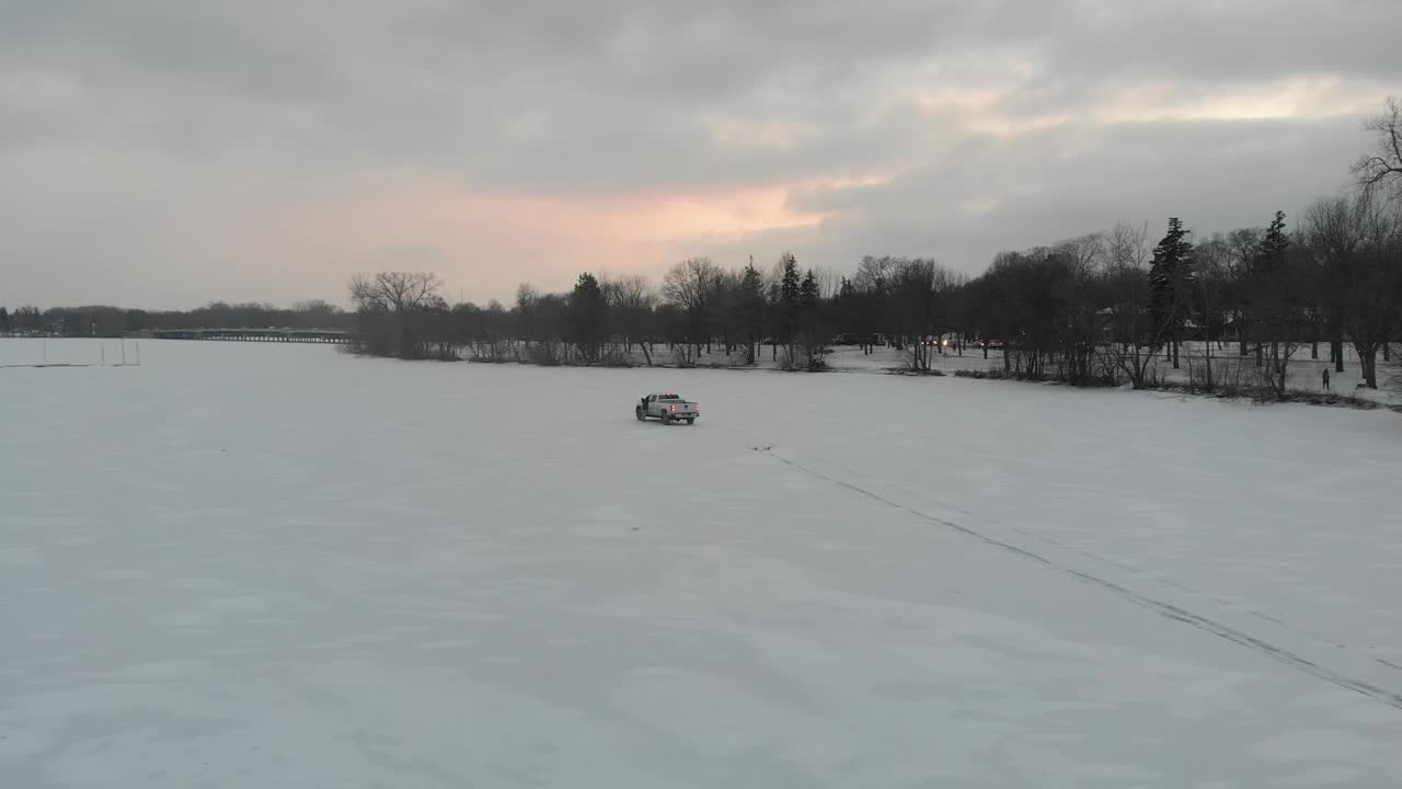 drone avanzando hacia un camión en una superficie de nieve