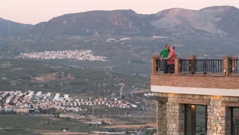 couple kissing on balcony with scenic mountain view