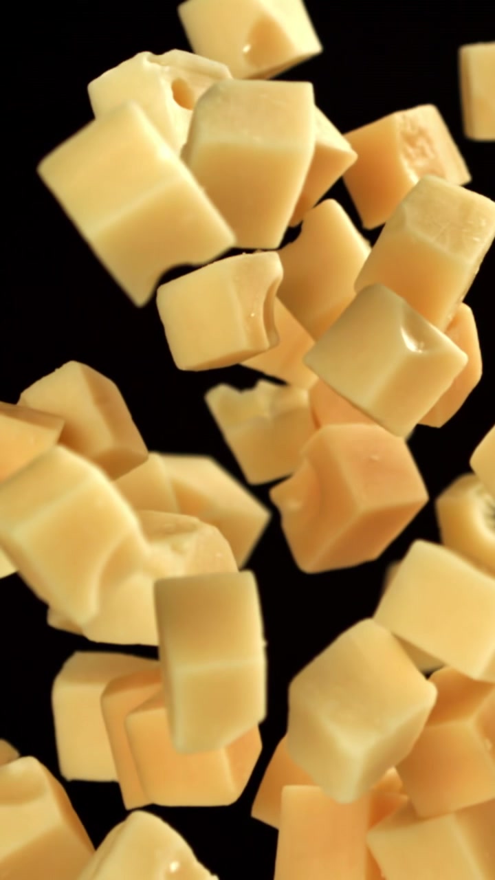 Cubetti di Formaggio che Salgono al Rallentatore su Sfondo Nero