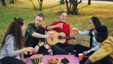 amigos disfrutando de un picnic en el parque con música