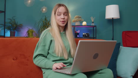 Woman-sitting-on-home-couch,-looking-at-camera,-making-video-conference-call-with-friends-or-family