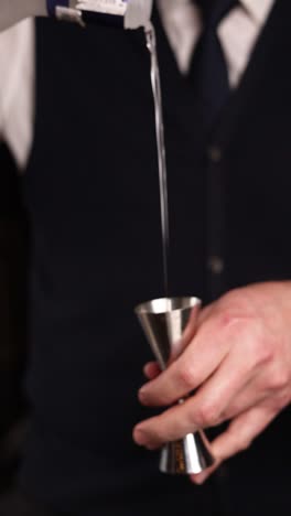 bartender pouring vodka into a jigger