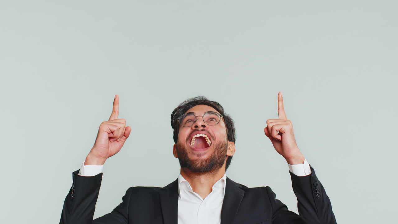 un hombre en traje señalando y sonriendo con una expresión feliz