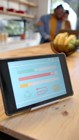 vertical video of tablet with smart home interface in kitchen, slow motion
