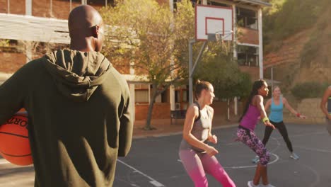 Diverso-Equipo-De-Baloncesto-Femenino-Y-Entrenador-Masculino-Jugando-Partido