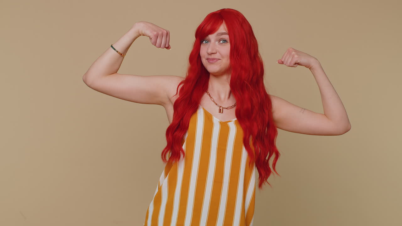 chica mostrando bíceps y pareciendo confiada, sintiendo poder fuerza para luchar por los derechos, el éxito ganar