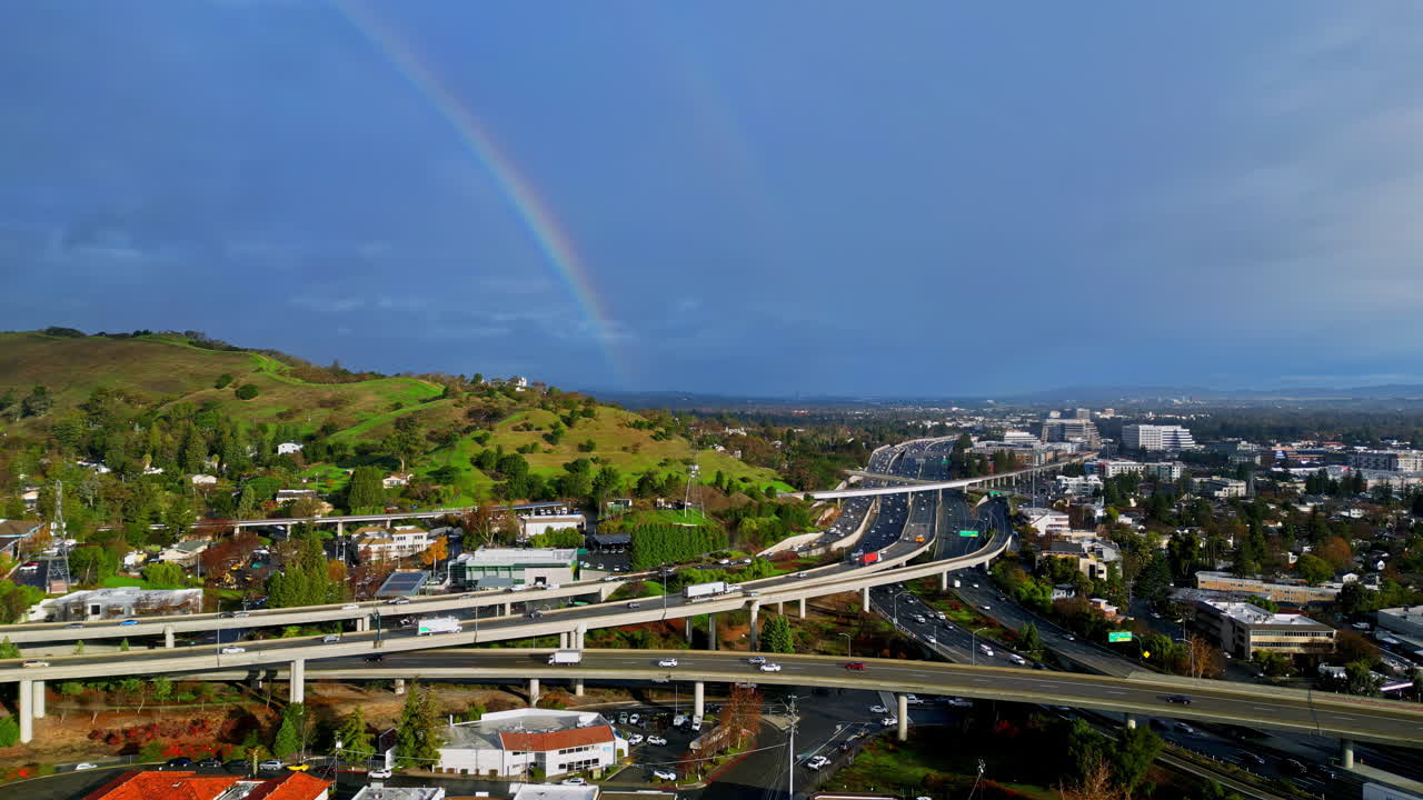 imágenes aéreas panorámicas de una complicada intersección de carretera, un arco iris en el cielo