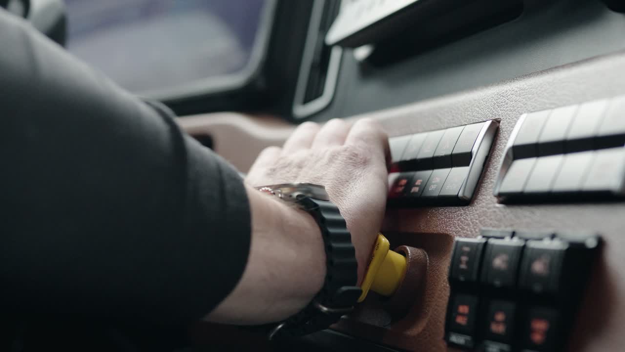 conductor de camión empujando con la mano la perilla de freno de estacionamiento de un nuevo freightliner cascadia volvo 2023