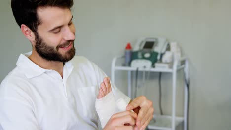 fisioterapeuta poniendo vendaje en los pies heridos del paciente