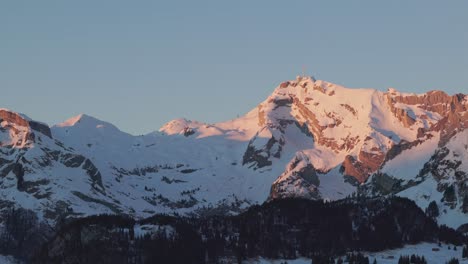 Vista-Aérea-Del-Amanecer-Que-Muestra-La-Silueta-De-Una-Cadena-Montañosa-Cubierta-De-Nieve