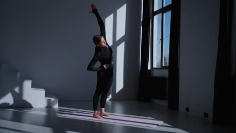mujer haciendo estiramiento de yoga en el estudio